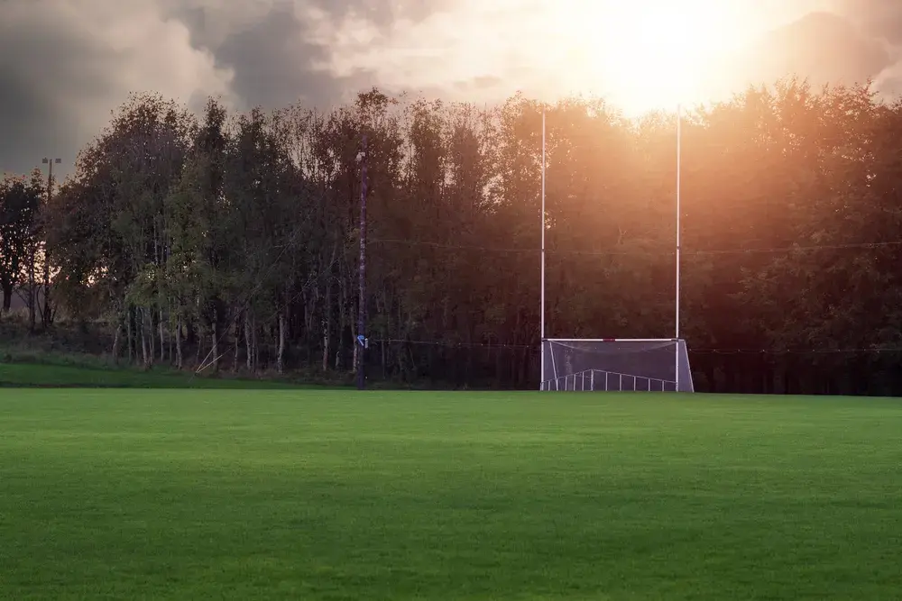 GAA goalposts on a training pitch at sunset